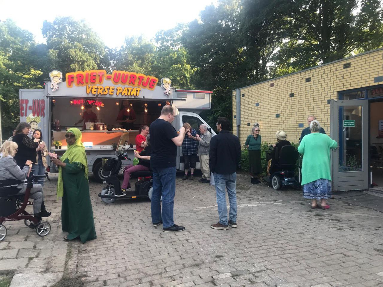 Bezoekers woonavond Buitenhof eten patatje van een frituurkraam